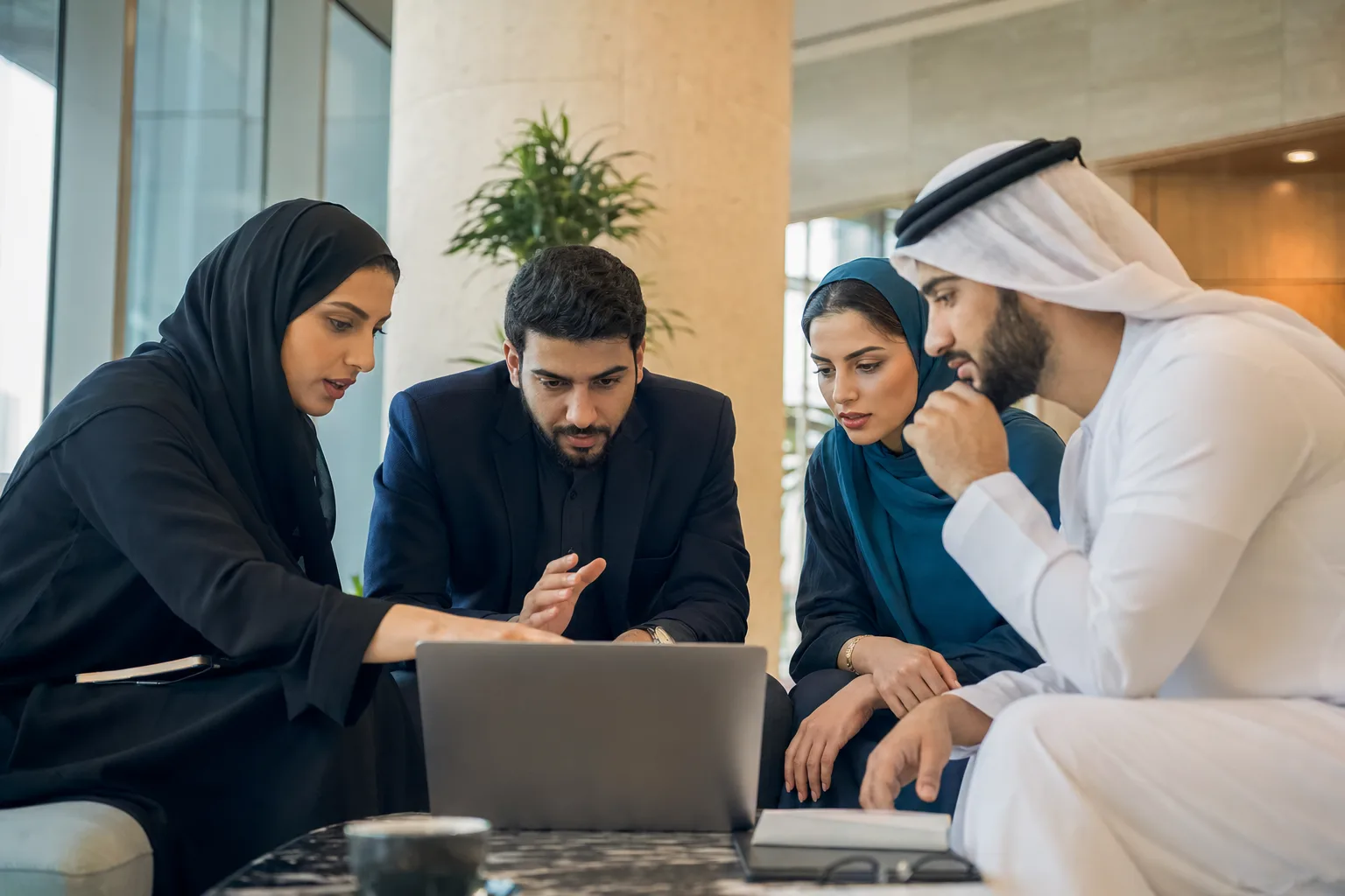 A small mixed team solving a problem around a laptop